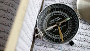 Ein Messgerät liegt auf einem aufgeschlagenen Buch mit arabischer Schrift © picture alliance / Godong | Pascal Deloche 