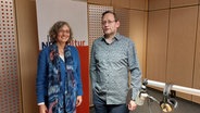 Eine Frau und ein Mann stehen nebeneinander in einem Studio. Im Hintergrund hängt ein Banner mit der Aufschrift NDR Kultur. © NDR Foto: NDR