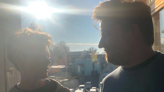Lisa Kreißler und Alexander Solloch stehen vor einem Fenster und werden vom Gegenlicht geblendet. © NDR Foto: Marisa Gruna