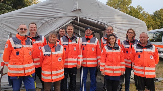 Mitglieder der Medical Task Force 13 Grevesmühlen posieren vor einem Zelt. © NDR Foto: Wiebke Heiden