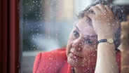 Eine Frau guckt bei Regen aus dem Fenster. © picture alliance / photothek | Liesa Johannssen 