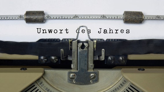 In einer manuellen Schreibmaschine ist ein Blatt eingezogen, auf dem "Unwort des Jahres" getippt ist. © picture alliance Foto: Sascha Steinach