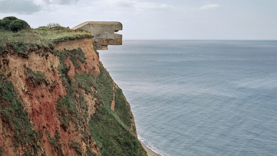 Ein Weltkriegsbunker ragt über eine Steilwand an der französischen Atlantikküste hinaus. © Annet van der Voort Foto: Annet van der Voort