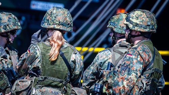 Eine Soldatin und drei Soldaten in der Rückenansicht. © picture alliance/dpa | Jens Büttner 