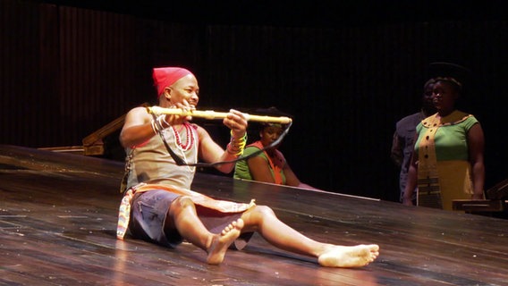 Ein Mann sitzt auf dem Boden und spielte eine Flöte © NDR 