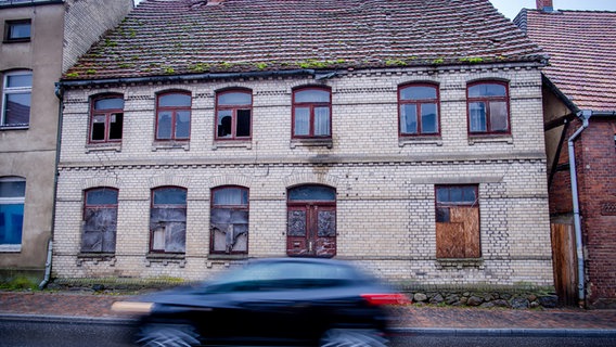 Zerbrochene Fenster, Dachrinnen und Dachziegel in einem leerstehenden Haus im Stadtzentrum. Leerstehende und teilweise heruntergekommene Wohn- und Gewerbebauten prägen die Kleinstadt Goldberg in Mecklenburg-Vorpommern. © picture Alliance/dpa Foto: Jens Büttner