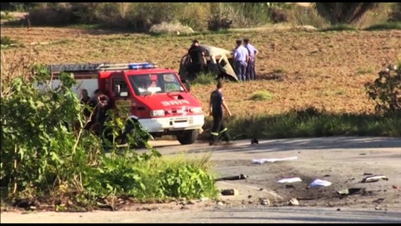 Das von einer Bombe zerstörte Auto der Daphne Caruana Galizia liegt auf einem Feld - die Journalistin kam bei dem Anschlag ums Leben. © NDR Foto: Screenshot