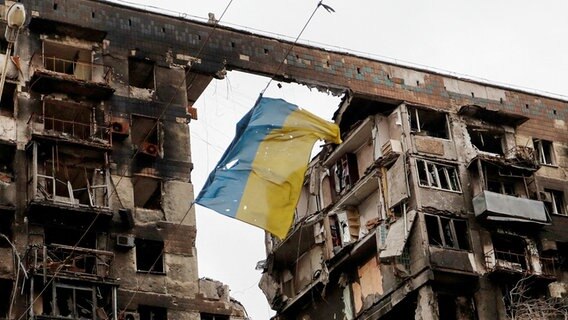 Eine ukrainische Flagge an einem zerstörten Gebäude in Mariupol © Reuters News Picture Service Foto: ALEXANDER ERMOCHENKO