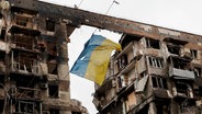 Eine ukrainische Flagge an einem zerstörten Gebäude in Mariupol © Reuters News Picture Service Foto: ALEXANDER ERMOCHENKO