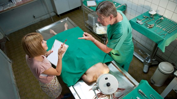 Klara (Wolke Hegenbarth, l.) diskutiert mit dem Pathologen Dr. Münster (Jörg Gudzuhn, r.) über den Obduktionsbericht. © ARD/Marion von der Mehden 