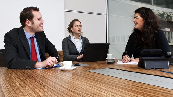 Besprechung im Büro: Drei Personen sitzen an einem Tisch. © Fotolia Foto: Phillip Minnis