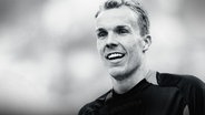 Ein lächelnder Robert Enke in sportlicher Kleidung.Das Bild ist in Schwarz-Weiß gehalten, der Hintergrund ist unscharf. © Imago / Lars Kaletta 