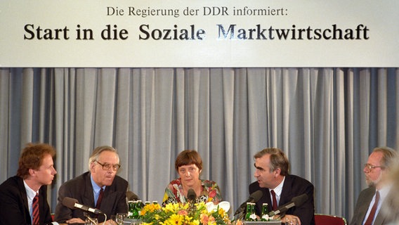 Angela Merkel (M.) als stellvetretende DDR-Regierungssprecherin am 1. Juli 1990, dem Tag der Währungsumstellung in der DDR. © picture alliance / ZB Foto: Karlheinz Schindler