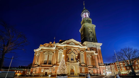 Die St. Michaelis Kirche mit Weihnachtstanne in der Dämmerung. © picture alliance / imageBROKER Foto: Christian Ohde