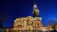 Die St. Michaelis Kirche mit Weihnachtstanne in der Dämmerung. © picture alliance / imageBROKER Foto: Christian Ohde