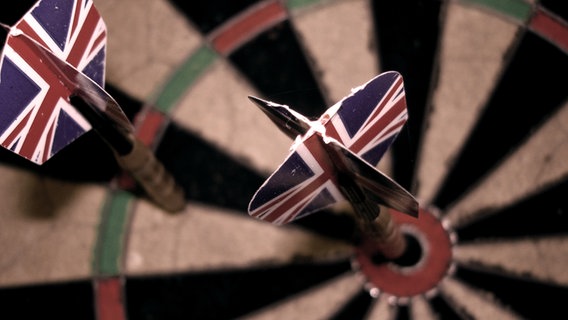 Zwei Dartpfeile mit der englischen Flagge als Flight stecken in einem Dartboard. © madochab / photocase.de Foto: madochab / photocase.de