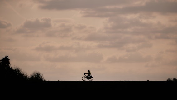 Ein Fahrradfahrer in der Dämmerung. © Photolights / photocase.de Foto: Photolights / photocase.de