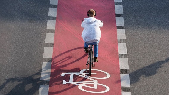 Ein Fahrradfahrer fährt mit Kopfhörern auf einem Radweg. © picture alliance / Wolfram Steinberg Foto: Wolfram Steinberg