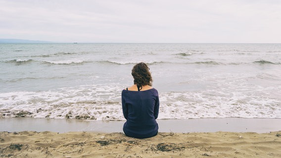 Eine Frau sitzt am Meer. © zaizev / photocase.de Foto: zaizev / photocase.de