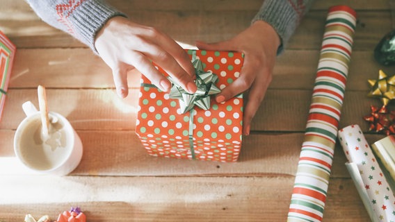 Mehrere eingepackte Geschenke liegen auf einem Tisch. © imago/Westend61 Foto: Westend61