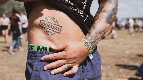 Ein Besucher des Hurricane Festivals 2019 zeigt sein Tattoo. © NDR/N-JOY Foto: Benjamin Hüllenkremer