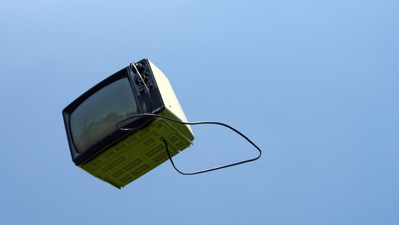 Ein alter Fernseher fliegt über den blauen Himmel. © Photocase / Stockwerk23 Foto: Photocase / Stockwerk23