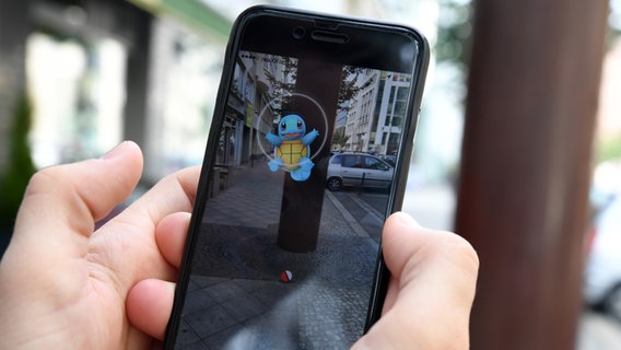 Auf einem Smartphone wird in "Pokémon Go" Glumanda gefangen. © picture alliance / dpa Themendienst Foto: Andrea Warnecke