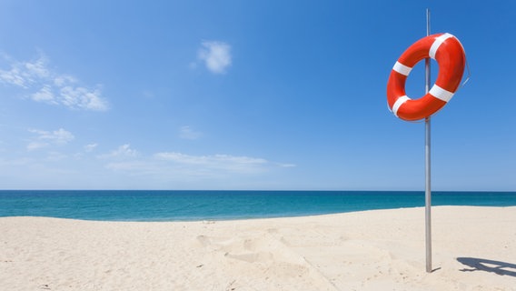 Ein Rettungsring hängt am Strand. © tagstiles.com / photocase.de 