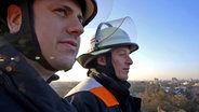 Hendrik Buth zusammen mit Feuerwehrmann Steven Eckardt auf der Drehleiter über Hamburg. © NDR/7 Tage Foto: Nikolas Müller