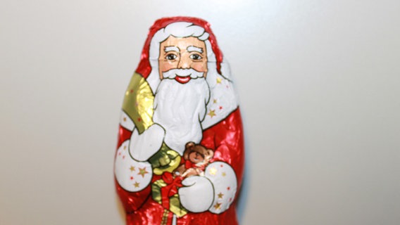 Das Bild zeigt einen eingepackten Schokoladen-Weihnachtsmann. © NDR 