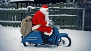 Ein Weihnachtsmann fährt auf einer Vespa durch den Schnee. © photocase Foto: -