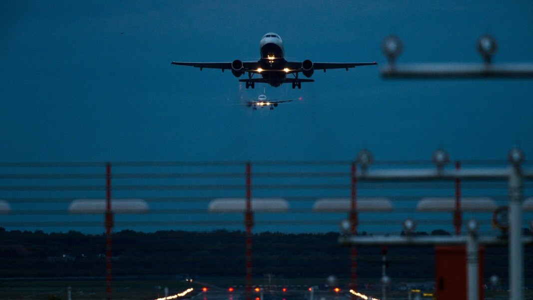 Ein Flugzeug startet im Dunkeln vom Hamburger Flughafen.
