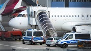 Ein Fahrzeug der Bundespolizei sichert die Maschine bei einer Abschiebung am Hamburger Flughafen Helmut Schmidt Airport. © picture alliance / ABBfoto | Foto: ABBfoto |