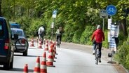 Radfahrer nutzen eine vorübergehend abgesperrte Straßenspur an der Hamburger Alster als Radweg. © picture alliance / dpa Foto: Christian Charisius