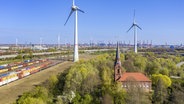 Blick auf Altenwerder im Hamburger Hafen: Im Vordergrund die Kirche St. Gertrud, links ist der Rangierbahnhof zu sehen, im Hintergrund Windräder und Hafenanlagen. © picture alliance / imageBROKER Foto: Andreas Werth