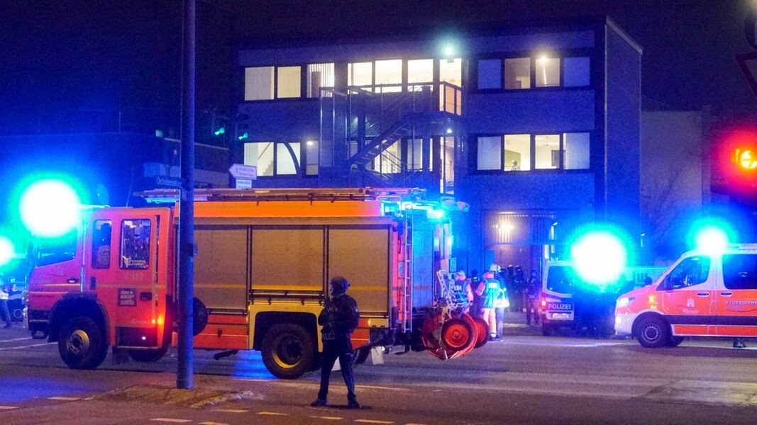 Rettungswagen, Sanitäter und Polizisten stehen nach einem Attentat in Hamburg-Alsterdorf vor einem Gebäude der Zeugen Jehovas
