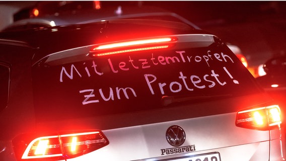 The words are written on the rear window of a vehicle in a motorcade 