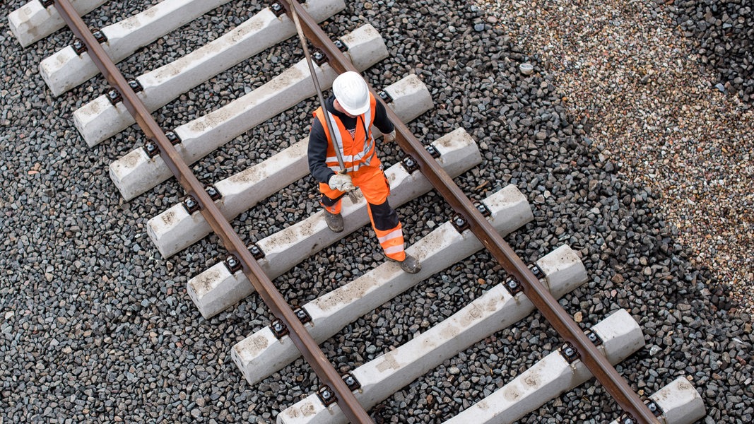 Ein Arbeiter geht in Hamburg über eine Gleisanlage der Bahn.