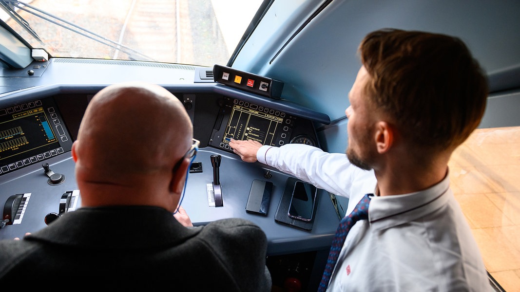 Ein Triebfahrzeugführer der Deutschen Bahn erklärt einem Bewerber in Hamburg-Altona den Führerstand eines ICE.