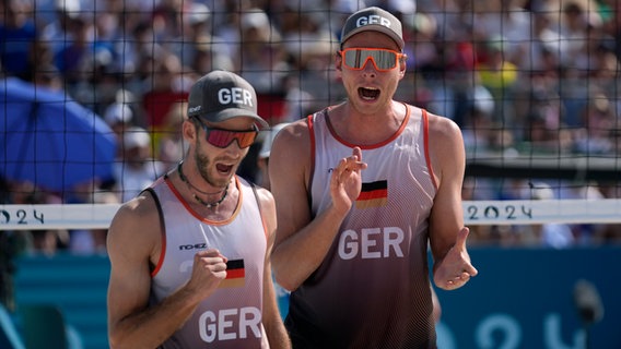 Clemens Wickler (l.) und Nils Ehlers bejubeln einen Punkt beim olympischen Beachvolleyball-Turnier in Paris. © picture alliance/dpa/AP Foto: Robert F. Bukaty