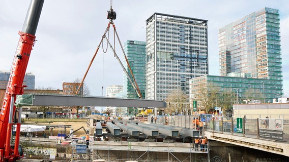 Ein Stahlträger wird auf der Baustelle der Berlinertordammbrücke mit einem Kran eingehoben. © dpa-Bildfunk Foto: Georg Wendt/dpa