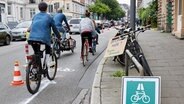 Radfahrer sind auf der durch Verkehrshüte makierten Pop-up-Radspur der Initiative Sternbrücke und des ADFC auf der Stresemannstraße in Richtung Pferdemarkt unterwegs. © picture alliance/dpa Foto: Georg Wendt