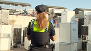 EIne Polizistin steht vor Kühlschränken in der Billstrasse. © TV News Kontor Foto: Screenshot