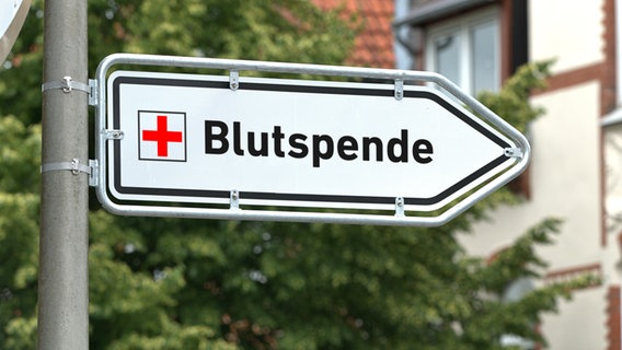 Ein weißes Hinweisschild an einem Laternenmast mit der Aufschrift "Blutspende". © picture alliance Foto: Torsten Sukrow