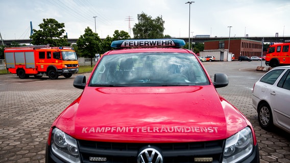 Einsatzfahrzeuge von Feuerwehr und Kampfmittelräumdienst stehen im Hamburger Stadtteil Waltershof. © Daniel Bockwoldt/dpa 