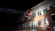 Feuer in einem Mehrfamilienhaus in Hamburg-Rahlstedt: Die Feuerwehr rettet Bewohner mit einer Drehleiter. © HamburgNews Foto: Chriistoph Seemann