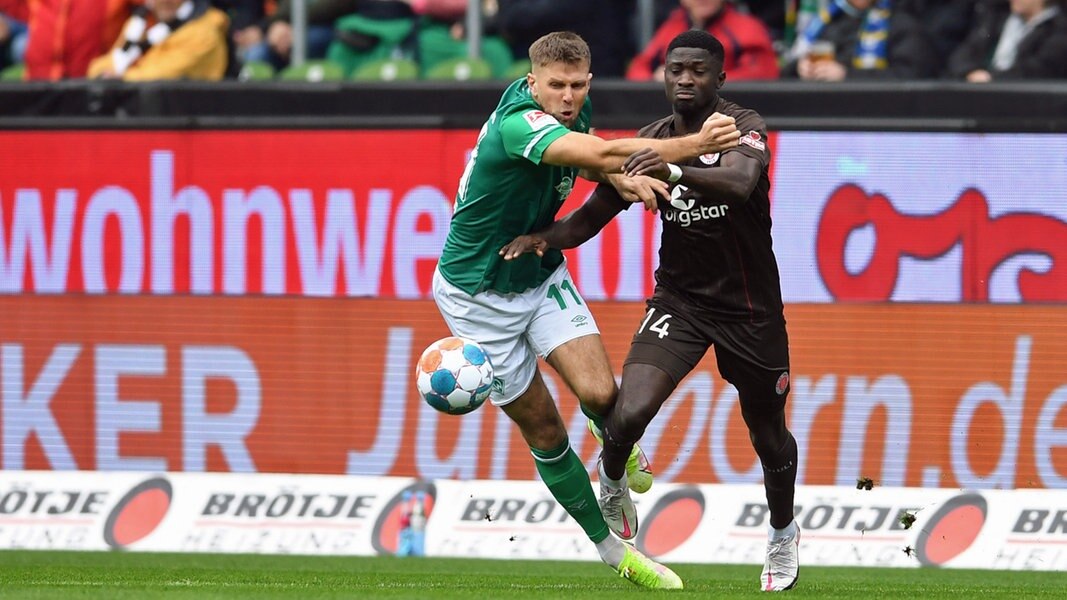 Werder Bremens Niclas Füllkrug (l.) kämpft gegen St. Paulis Afeez Aremu um den Ball.