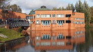 Das Bürgerhaus in Hamburg-Wilhelmsburg spiegelt sich im Wasser. © Bürgerhaus Wilhelmsburg Foto: Katja Scheer