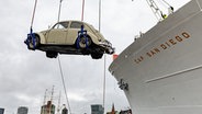 Mit dem eigenen Schiffs-Ladekran wird ein VW Käfer an Bord des Museumsschiffs "Cap San Diego" im Hamburger Hafen gebracht. © picture alliance / dpa Foto: Axel Heimken