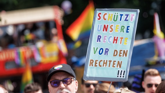 Ein Teilnehmer hält auf der Demonstration zum Christopher Street Day (CSD) ein Schild mit der Aufschrift "Schützt unsere Rechte vor den Rechten!". © picture alliance/dpa Foto: Markus Scholz